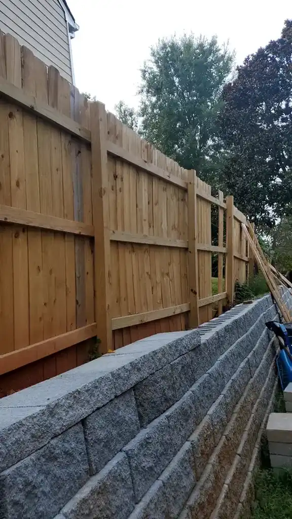 Wood privacy fence by retaining wall